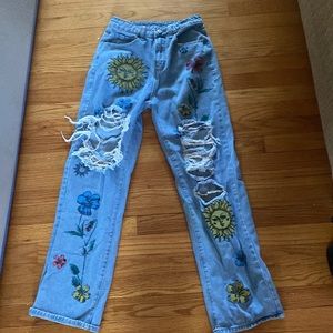 Ripped blue jeans with sun and flowers perfect for a spring day.